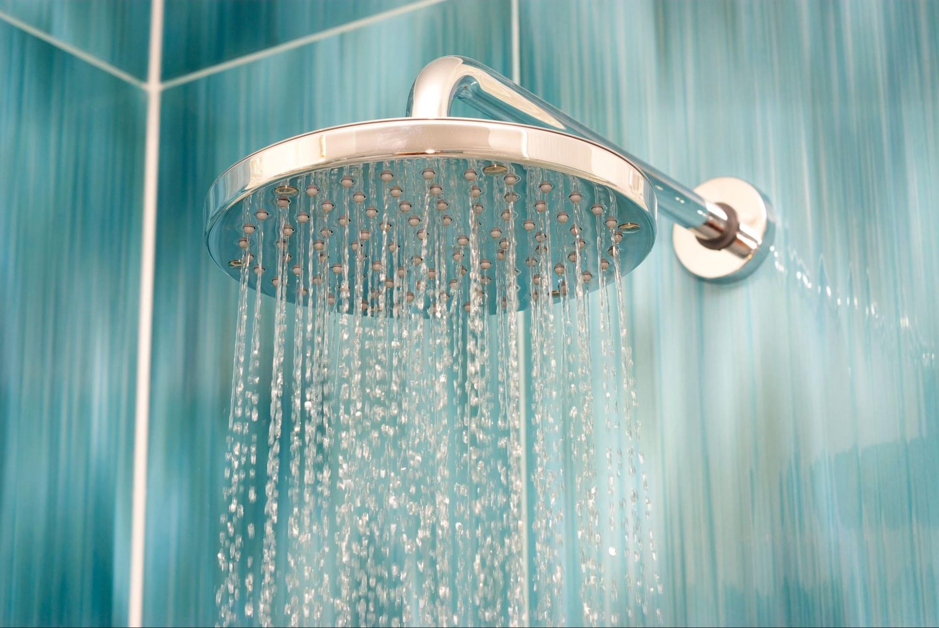 a shower head with water coming out of it in a bathroom .