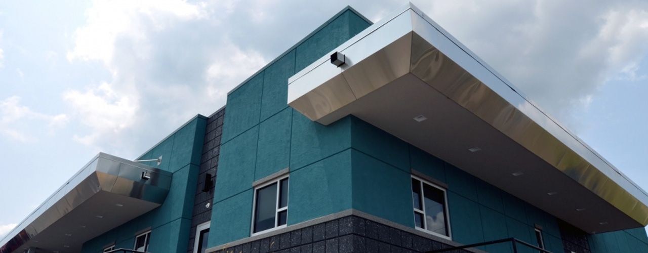 A large blue building with a balcony on the side of it.