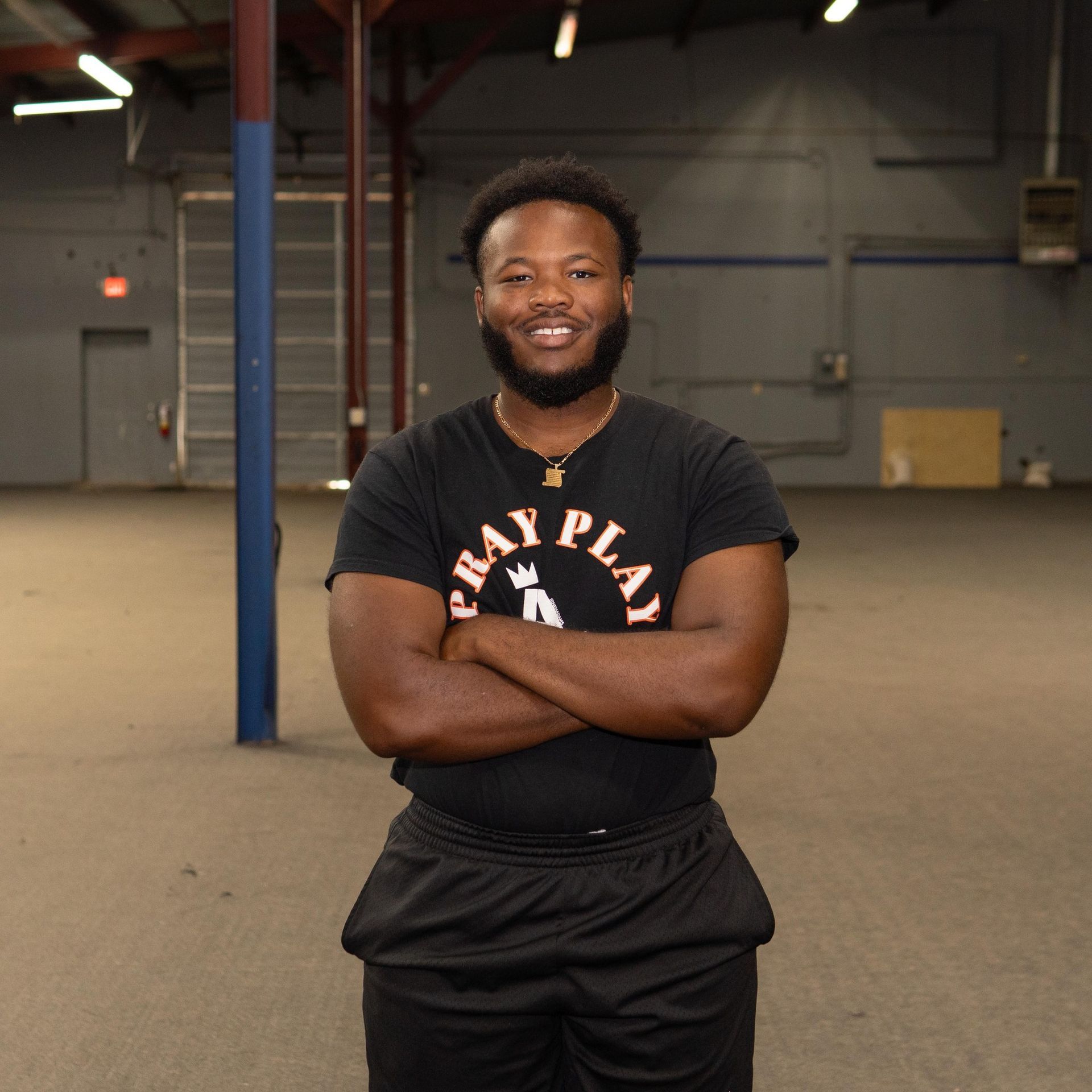 A man wearing a black shirt that says bay play