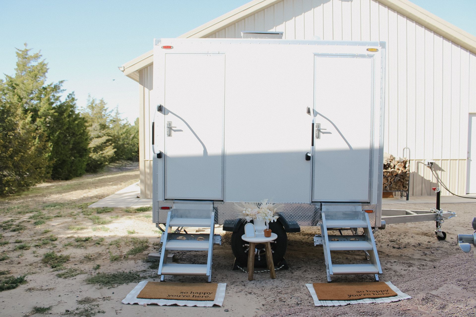 People queue for portable toilets at an outdoor event, under a cloudy sky.