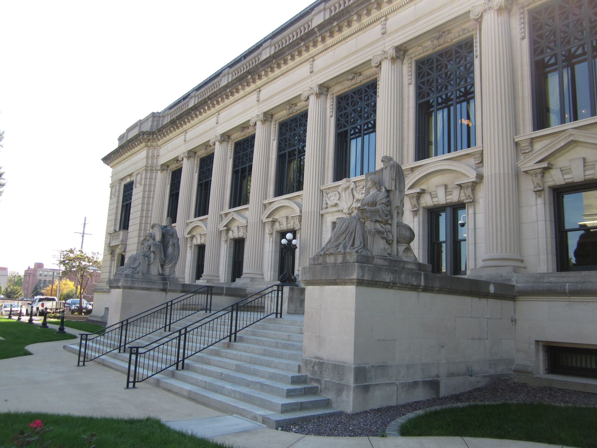 Stone courthouse with steps, columns, and sculptures.
