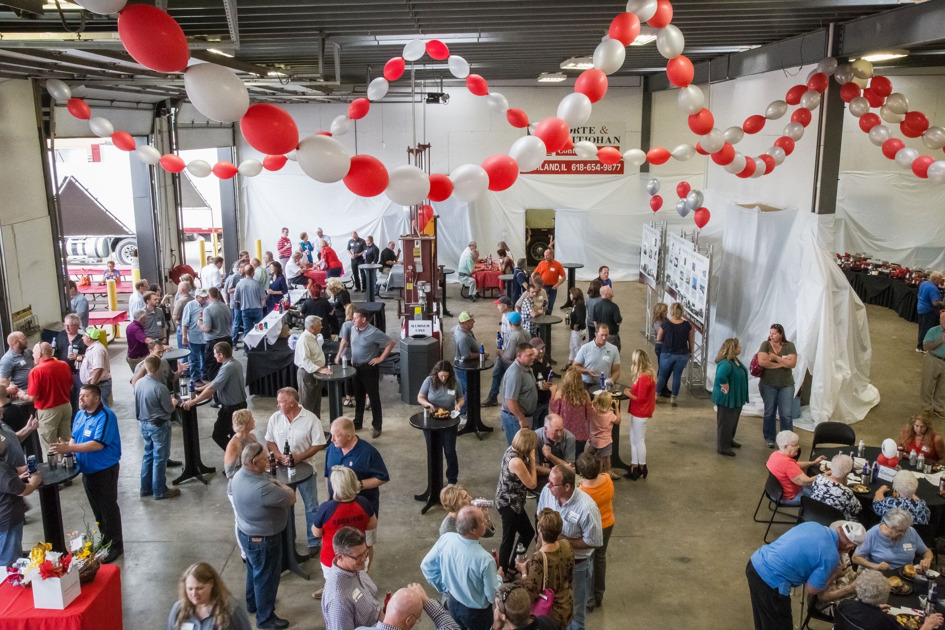 Group photo of employees in front of the K & L building, many in work attire.