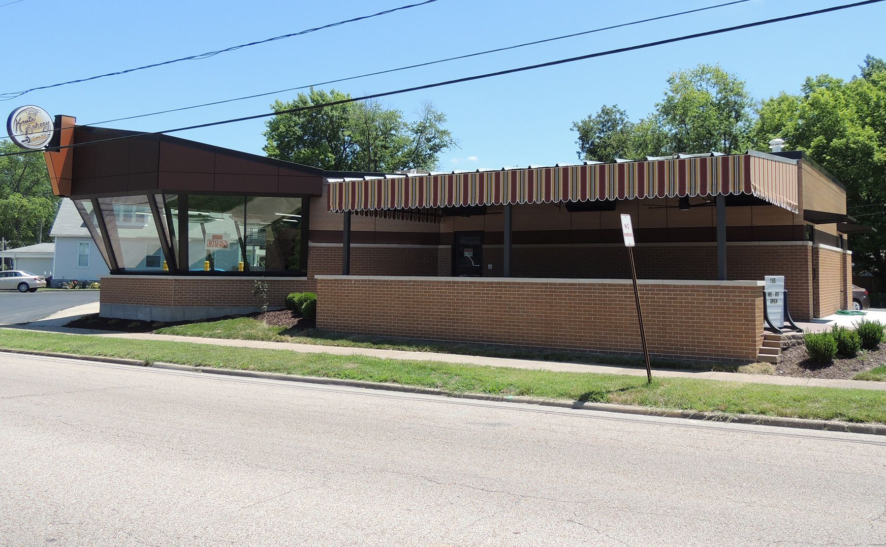 Bar interior with stools, liquor bottles, and a lit sign.
