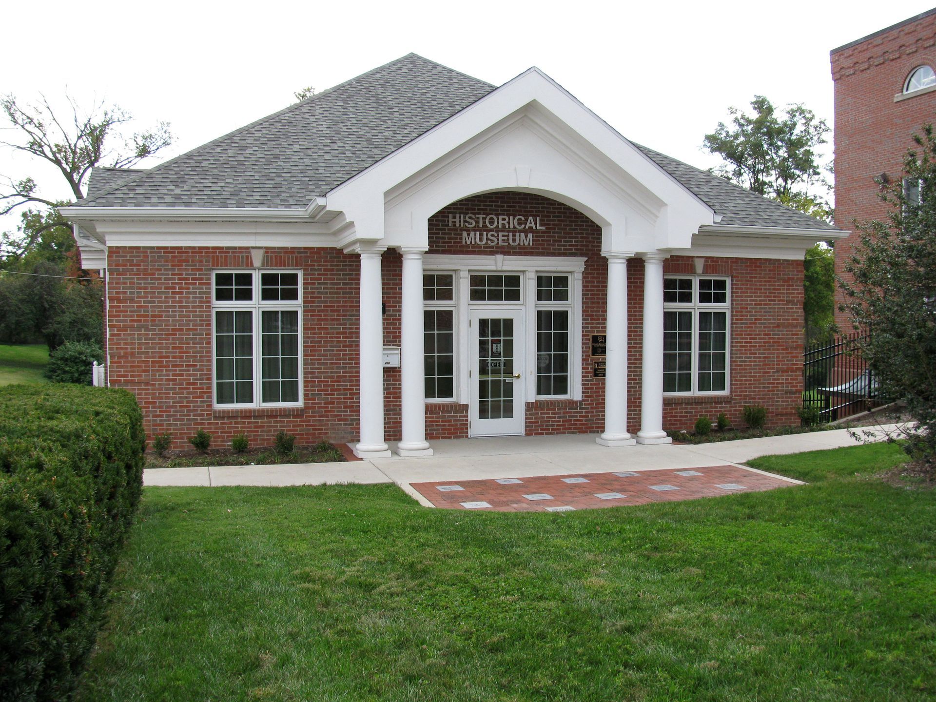 Brick building with columns and a gable roof, likely a library.