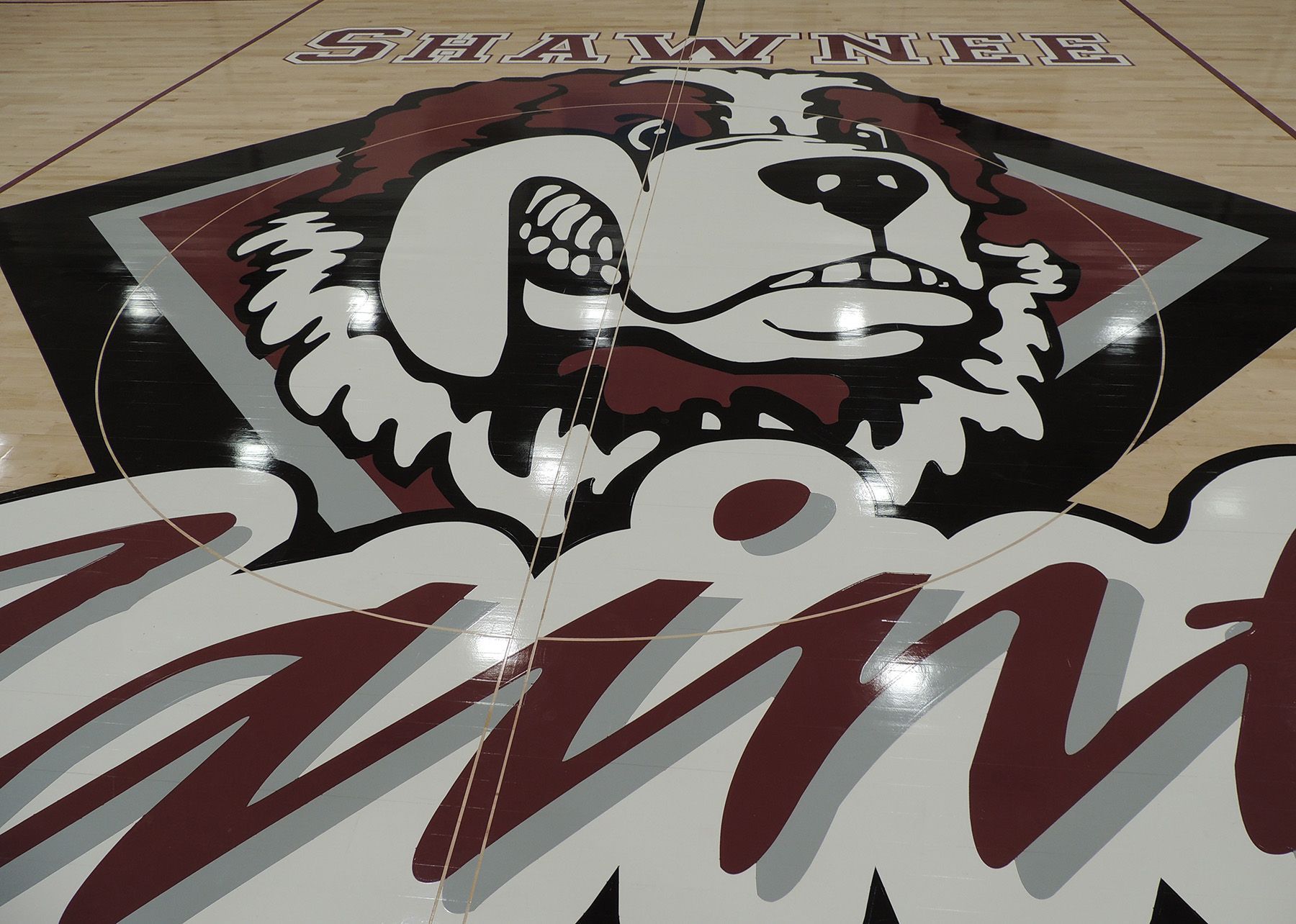 Study room with tables, chairs, and glass-walled rooms; overhead lighting on the ceiling.