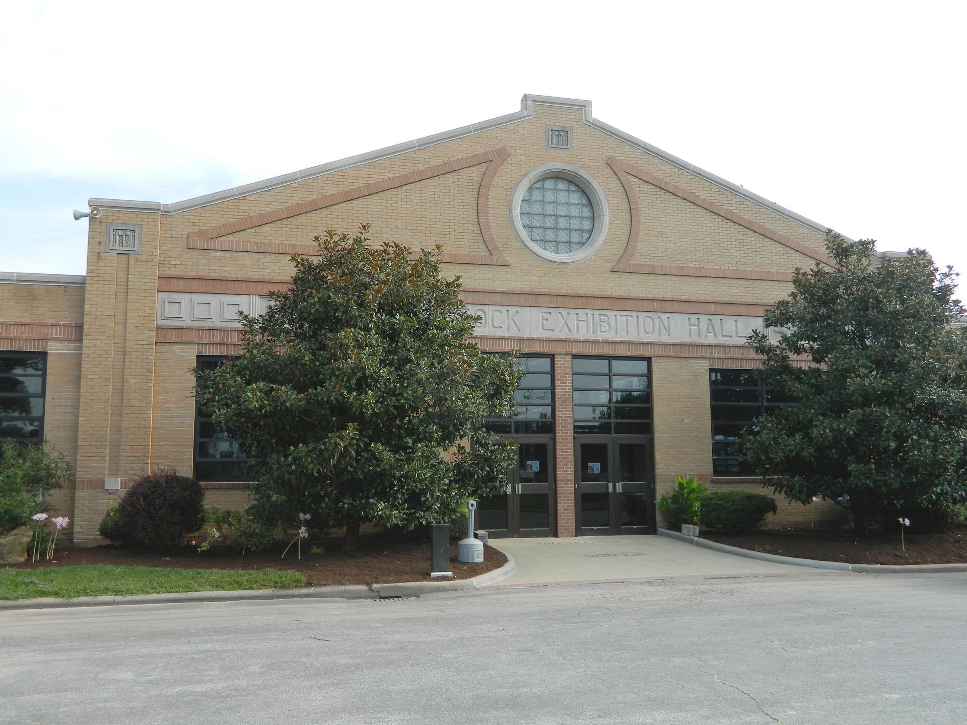 Tan brick building with arched roof, circular window, and