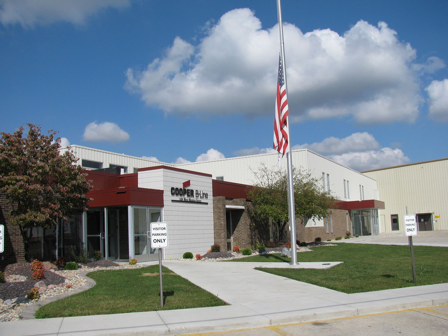 Building with red trim and an American flag on a sunny day.