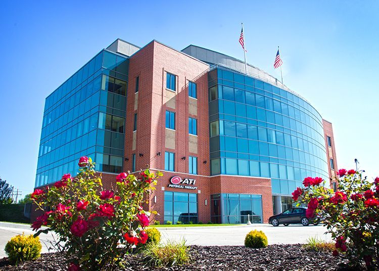 Two men digging in a dark earthen pit, one holding a tool, the other using a shovel.