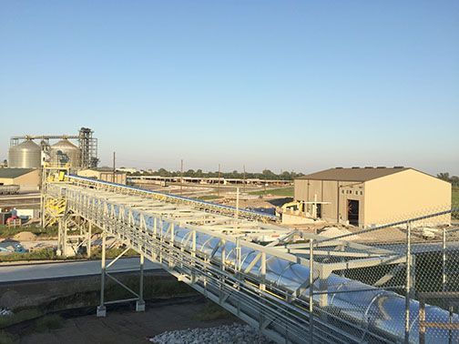 Industrial facility with a long conveyor belt bridge.