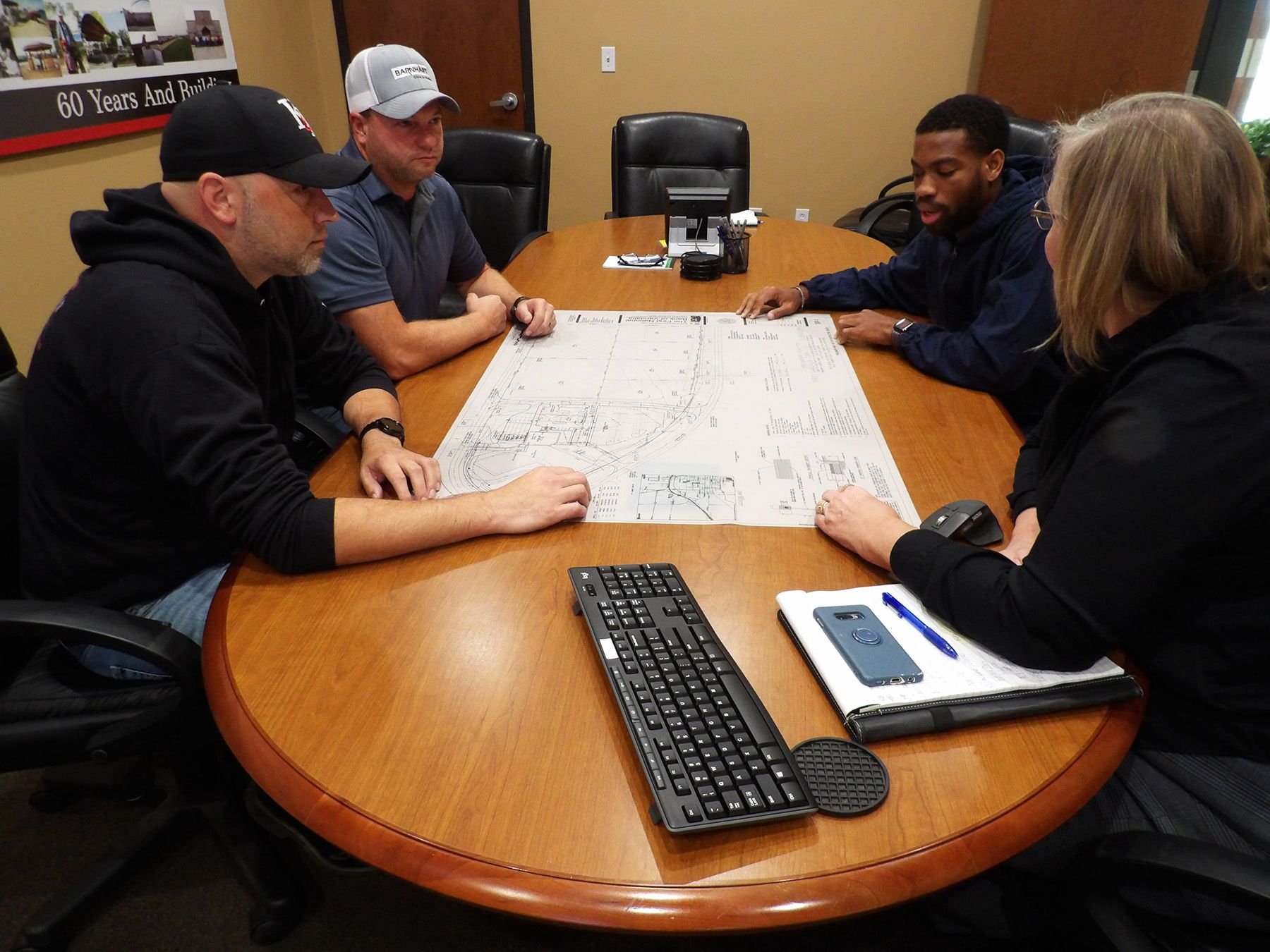 Concrete pumping truck near green trees and signs.