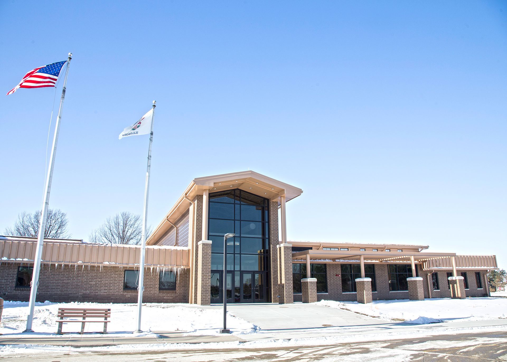 Building with US and Illinois flags; snow on the ground.