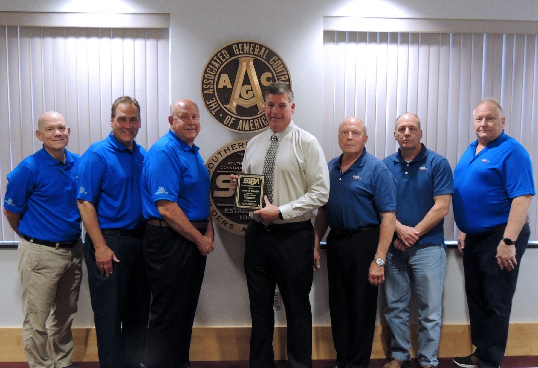 Concrete pumping truck near green trees and signs.