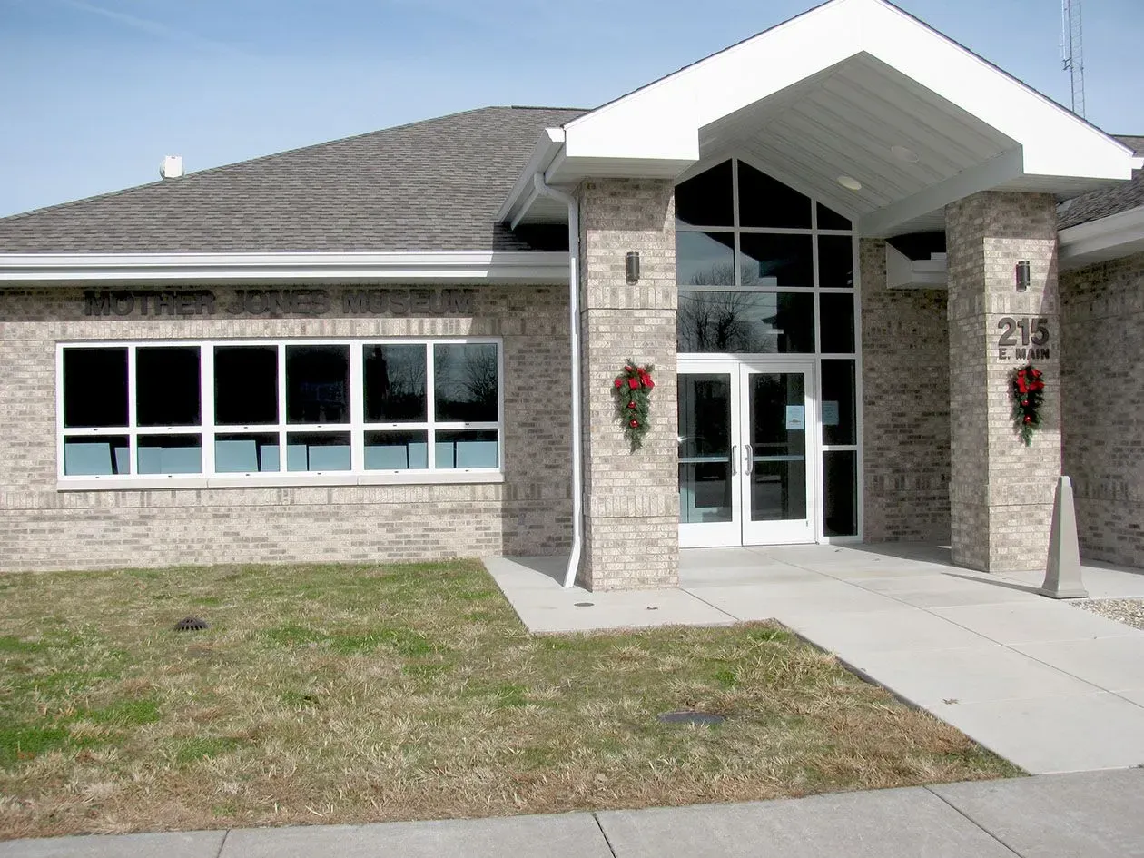 Brick building with large windows and a covered entrance; address 215 Park visible.