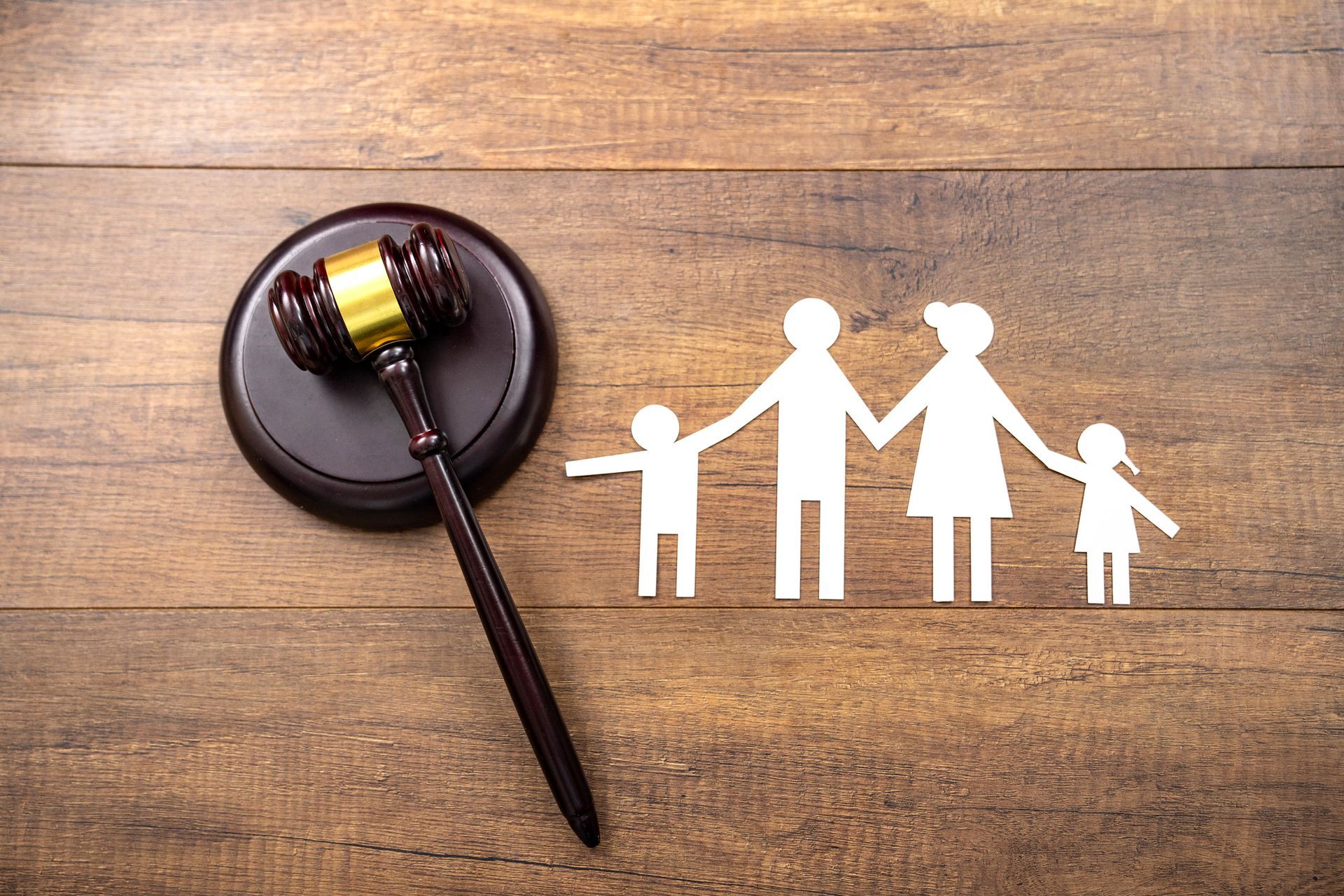 Tag-Wooden gavel and paper cutout family on table, symbolising family law.