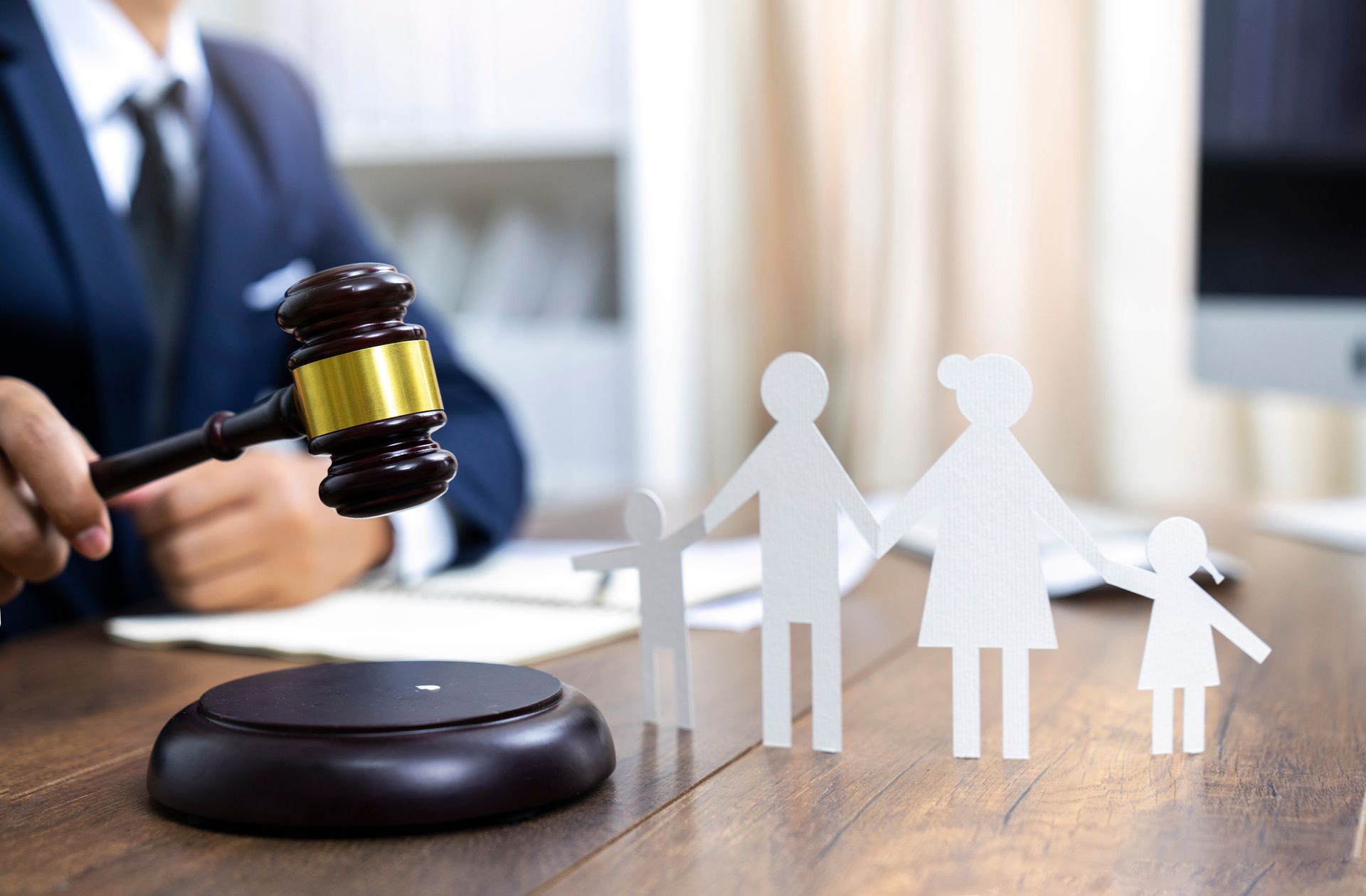 Judge with gavel and paper cutout family on desk, symbolizing family law.