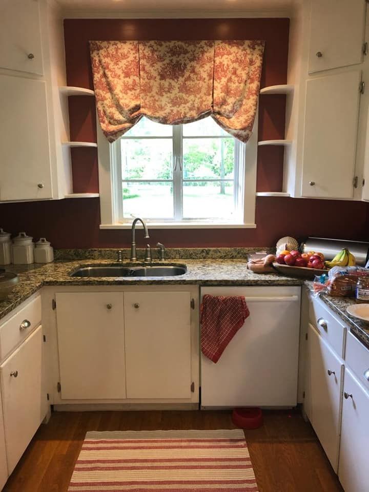 A kitchen with a sink , dishwasher , and window.