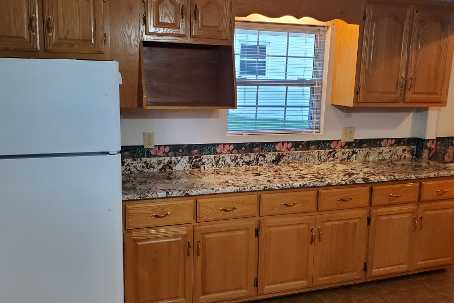 A kitchen with wooden cabinets and a white refrigerator