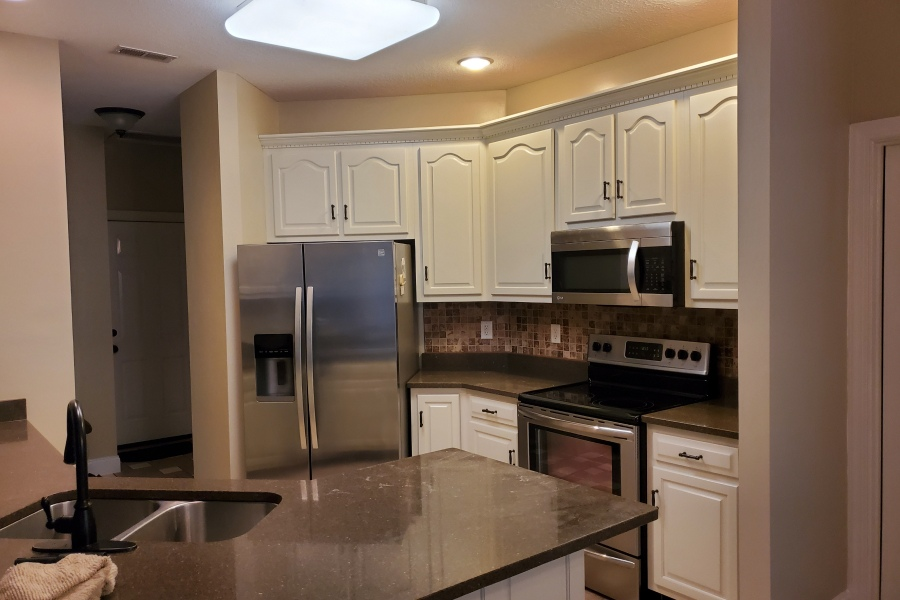 A kitchen with white cabinets and stainless steel appliances.