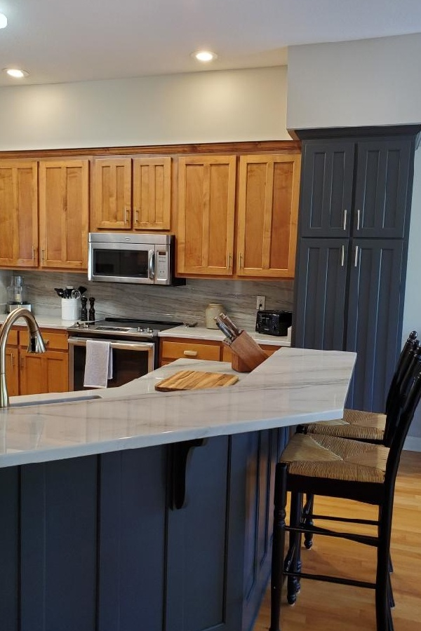 A kitchen with wooden cabinets and a large island