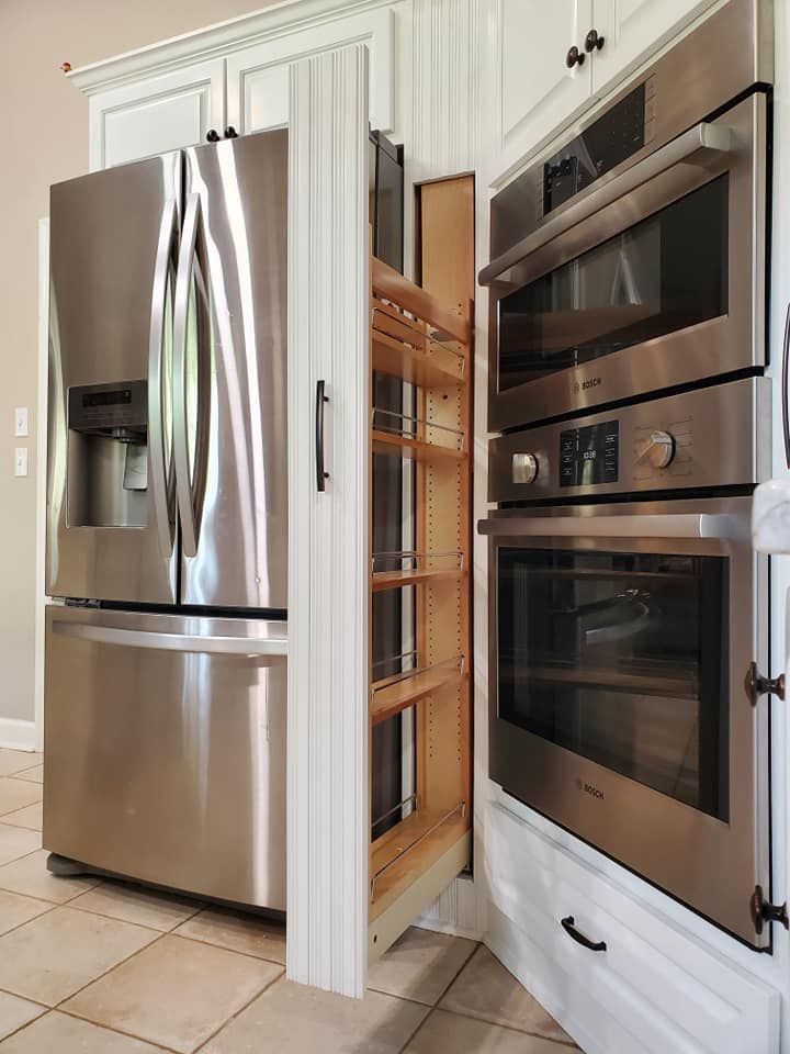 A kitchen with stainless steel appliances and white cabinets