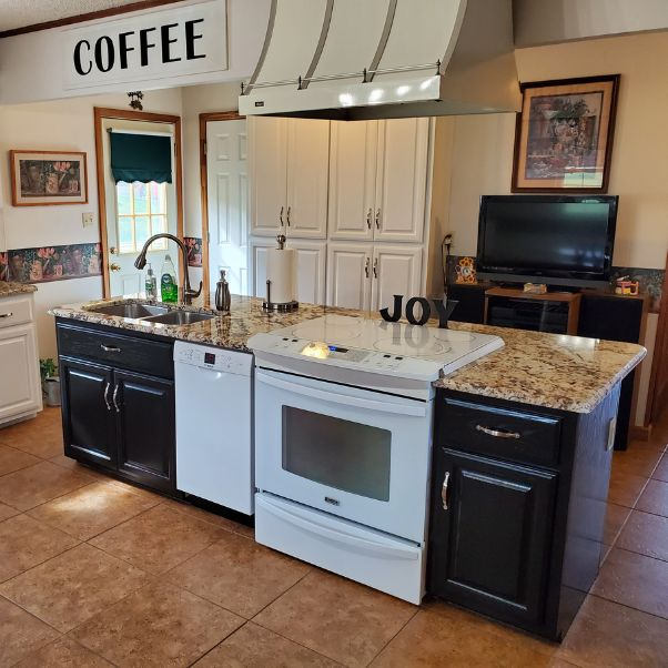 A kitchen with a coffee sign above the stove