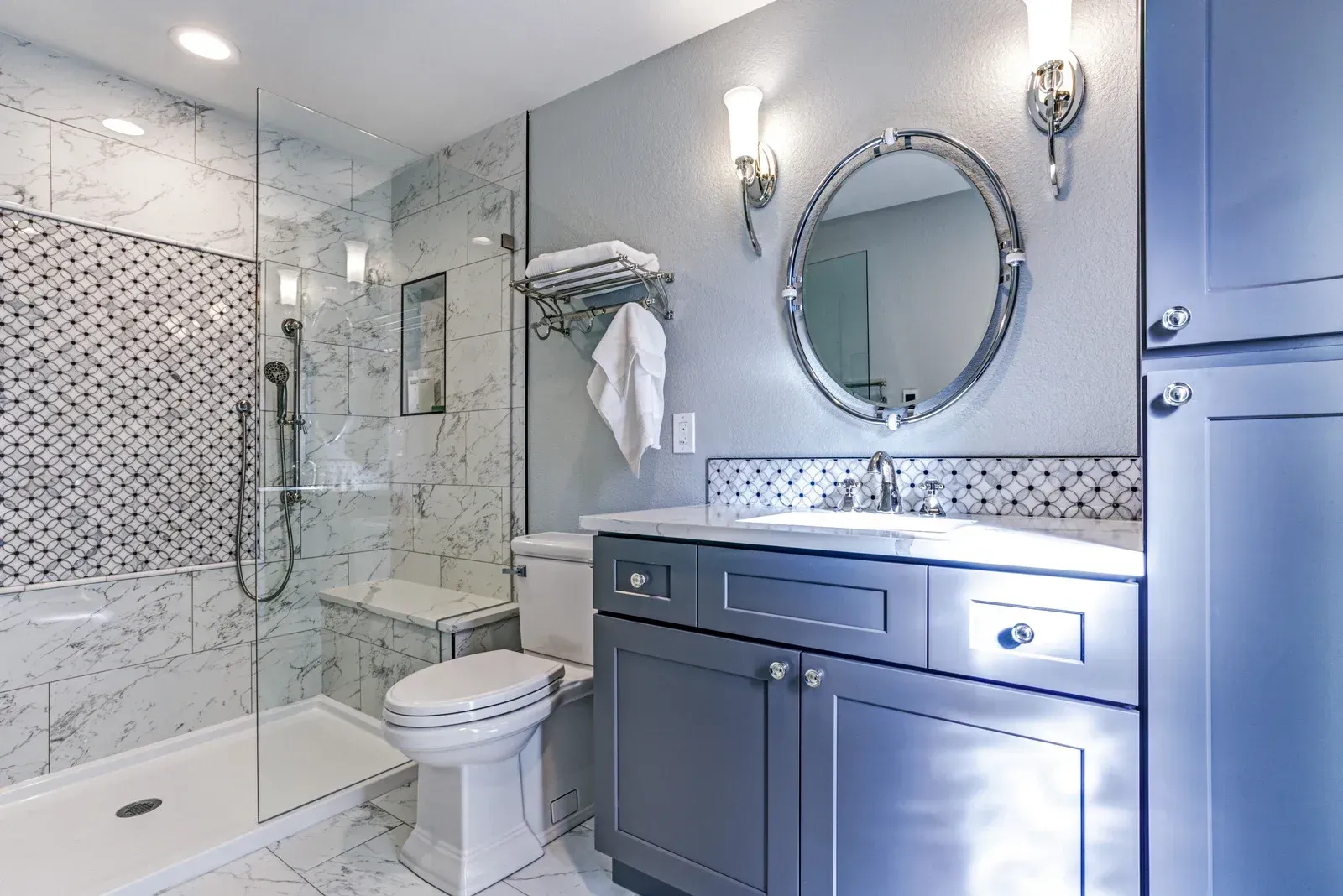 A bathroom with a toilet , sink , mirror and walk in shower.
