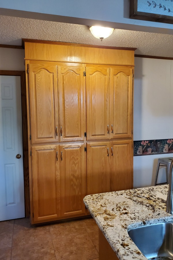 A kitchen with a large cabinet and a sink.
