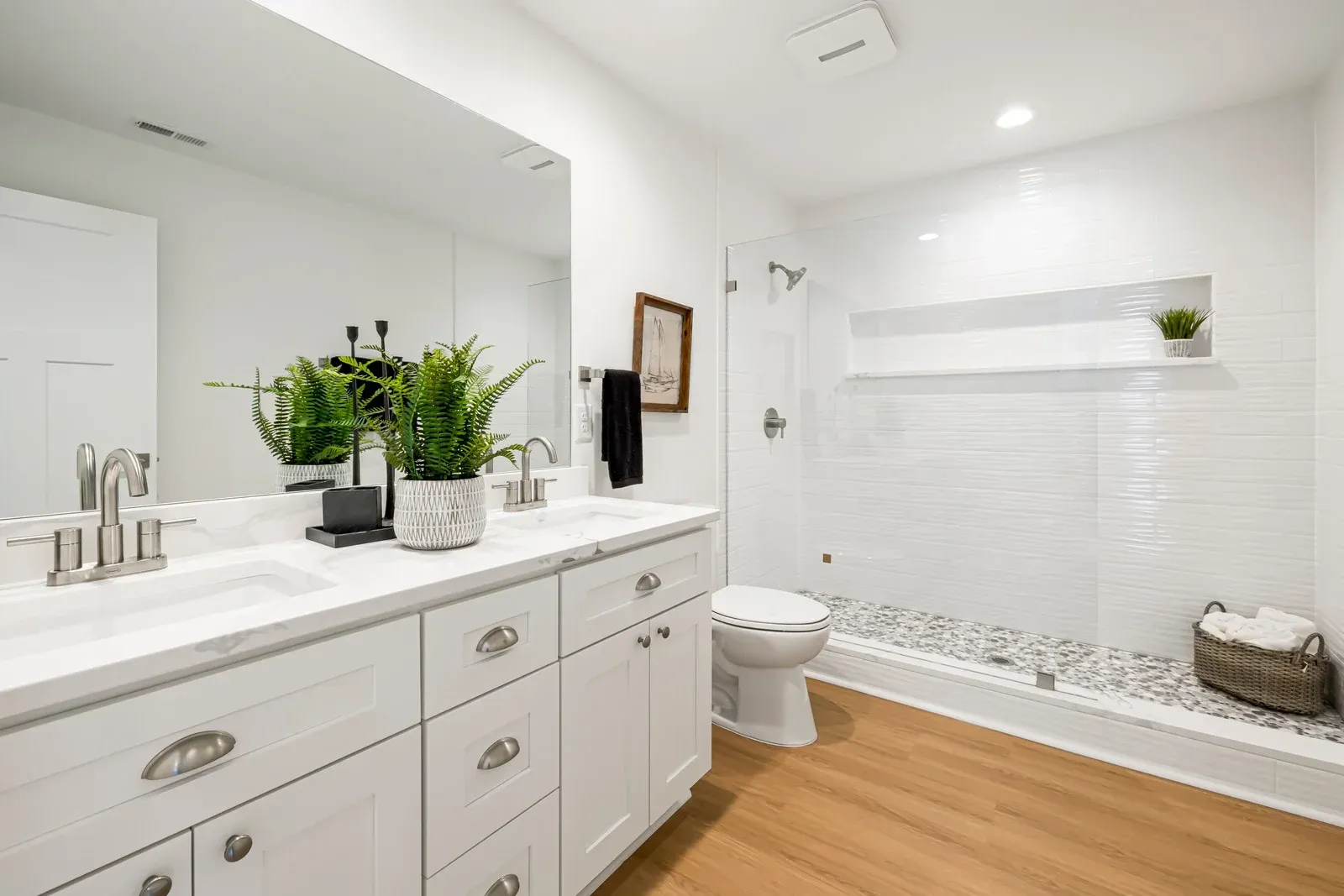 A bathroom with two sinks , a toilet , and a shower.
