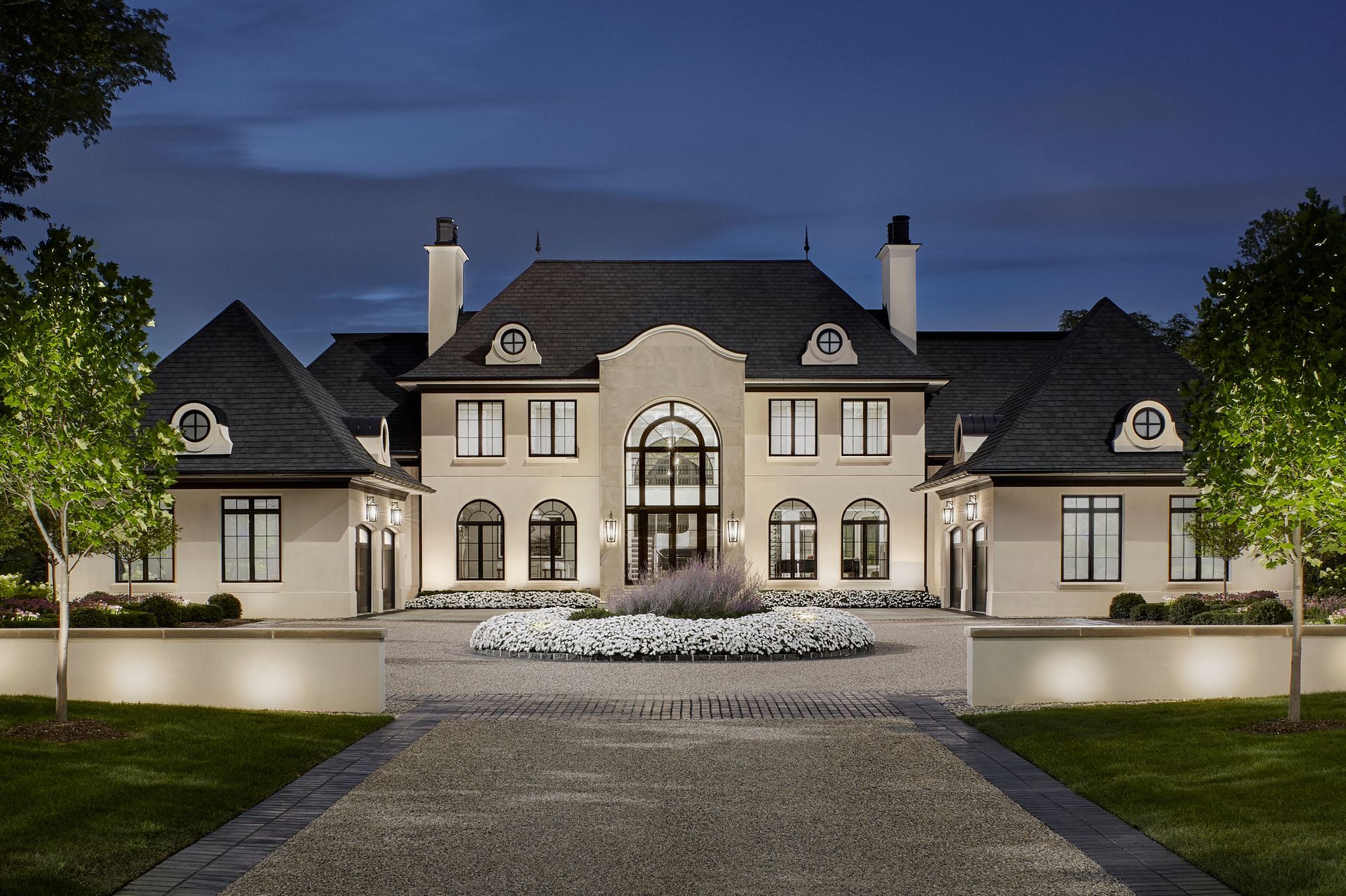 A large house with a gravel driveway leading to it