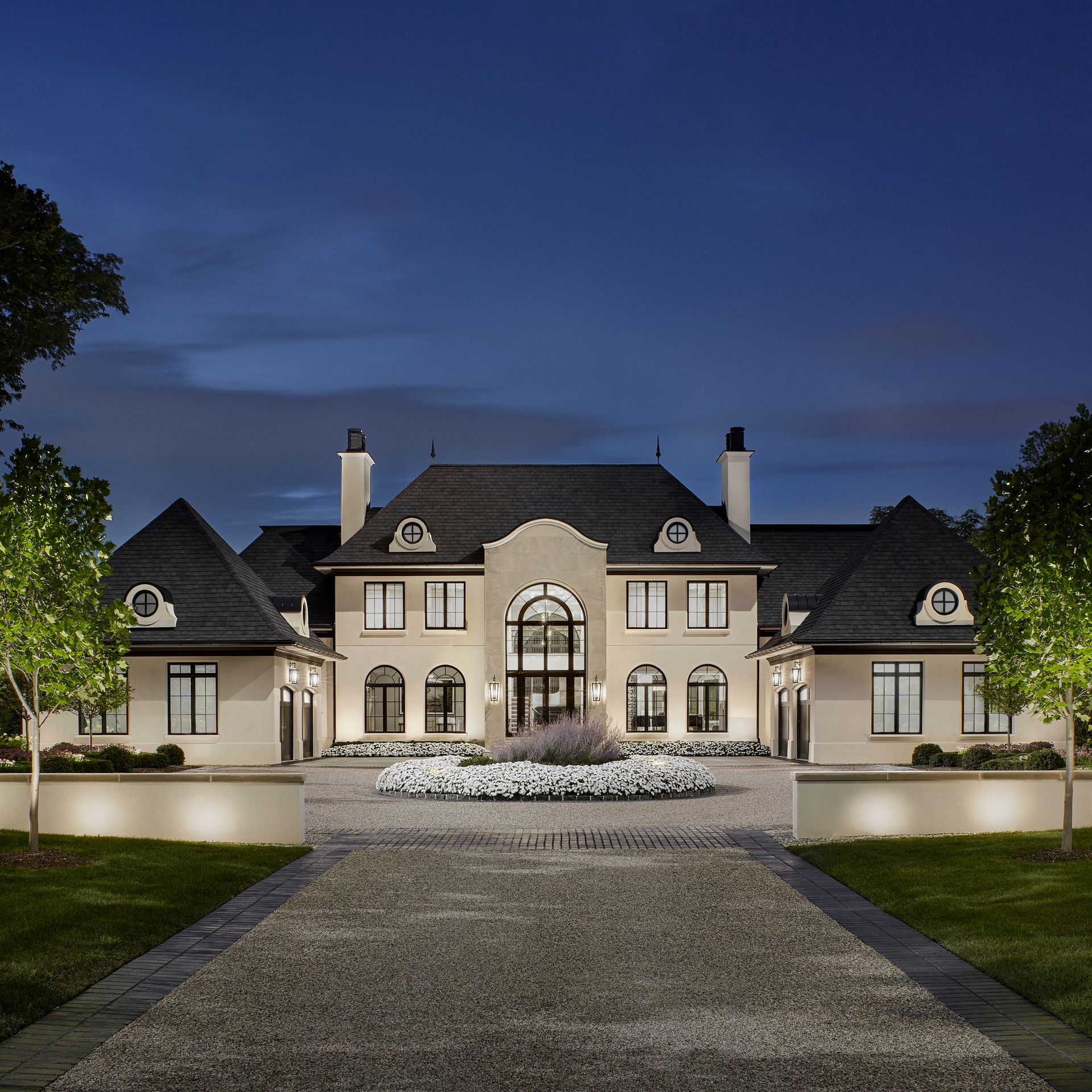 A large white house is lit up at night