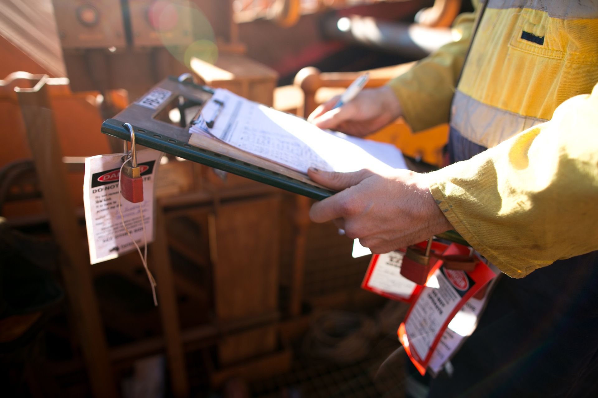 A man is holding a clipboard and writing on it