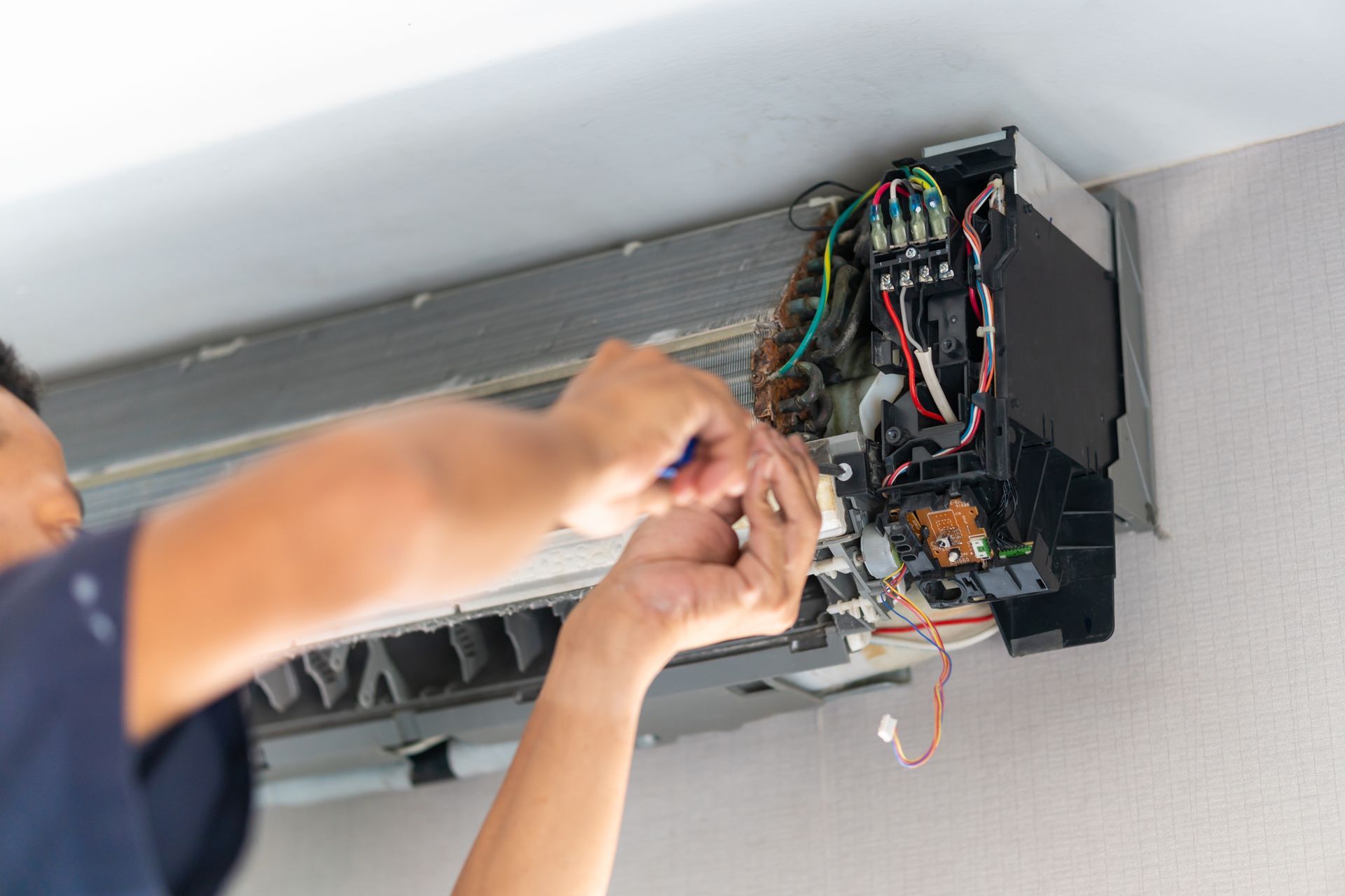 HVAC technician repairing a residential air conditioner during a service call