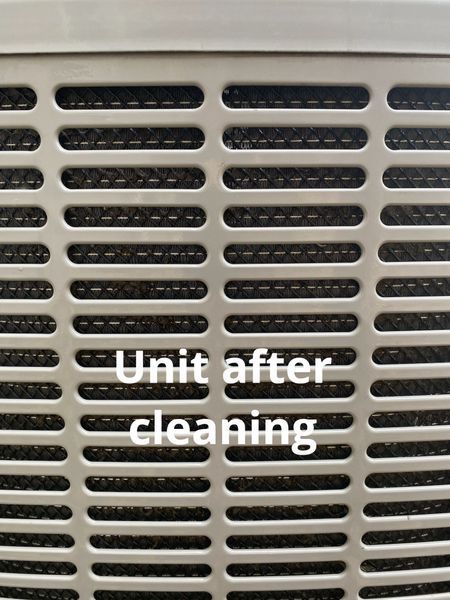 Close-up of a cleaned, metallic HVAC unit grille with the text