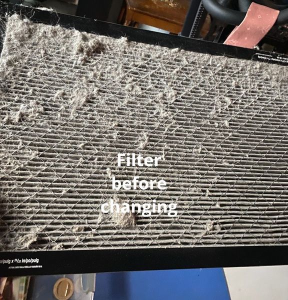 A dirty air filter covered in dust and debris, labeled 