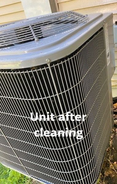 Gray air conditioning unit after cleaning, outdoors.