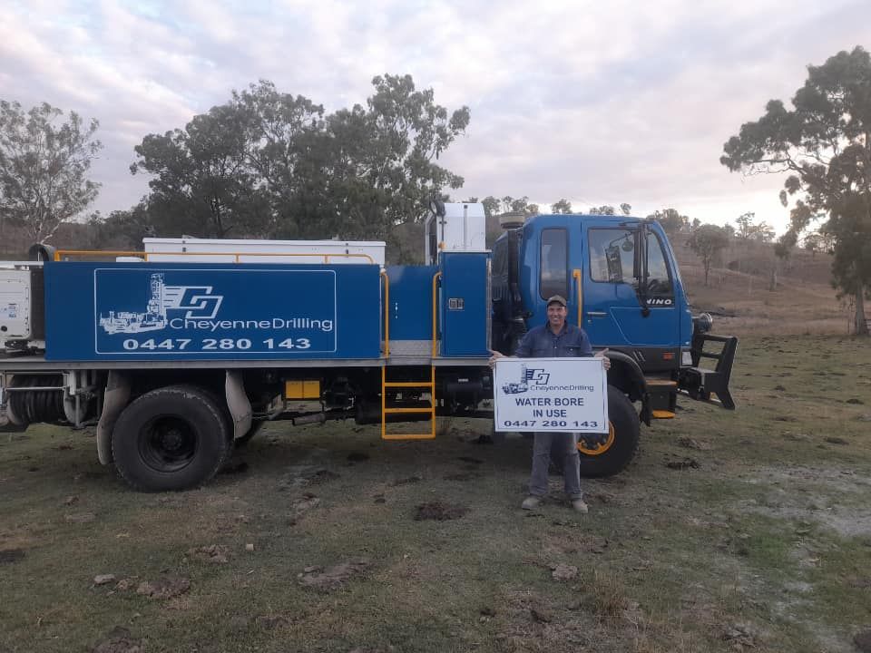 A Man Holding a Sign in Front of a Blue Truck — Cheyenne Drilling on the Sunshine Coast, QLD