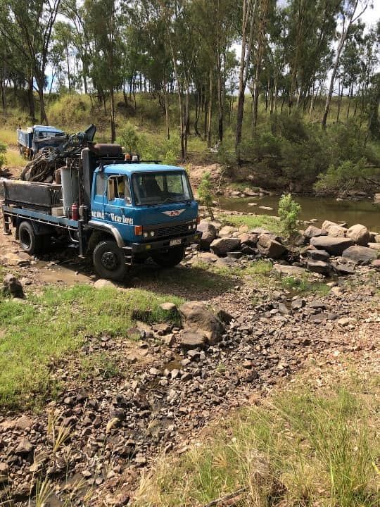 A Blue Truck is Parked on the Side of a Dirt Road Next to a River — Cheyenne Drilling on the Sunshine Coast, QLD