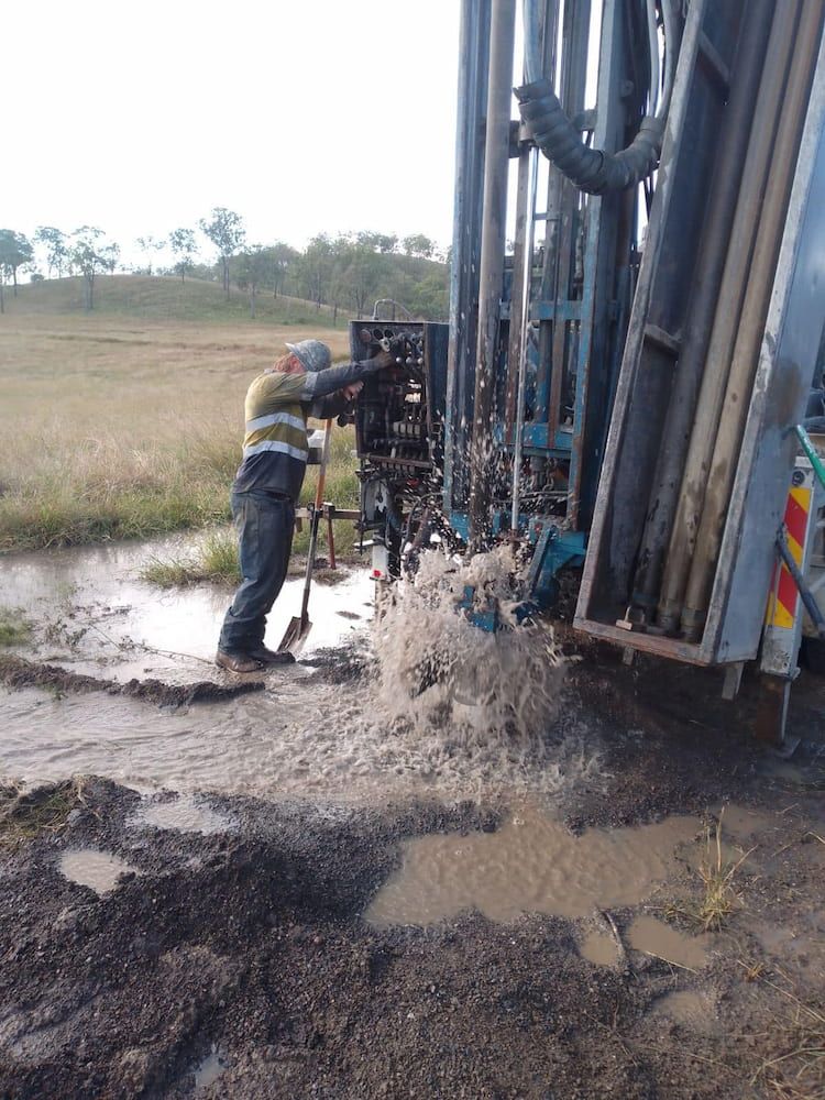 A Man is Working on a Machine in a Muddy Field — Cheyenne Drilling in Fraser Coast, QLD