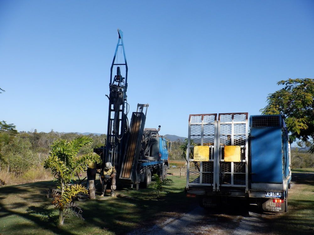 A Blue Truck is Parked Next to a Large Machine in a Field — Cheyenne Drilling on the Sunshine Coast, QLD