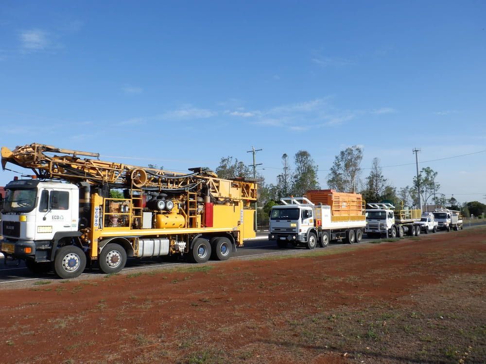 A Row of Trucks Are Parked Next to Each Other on a Dirt Road — Cheyenne Drilling in Fraser Coast, QLD