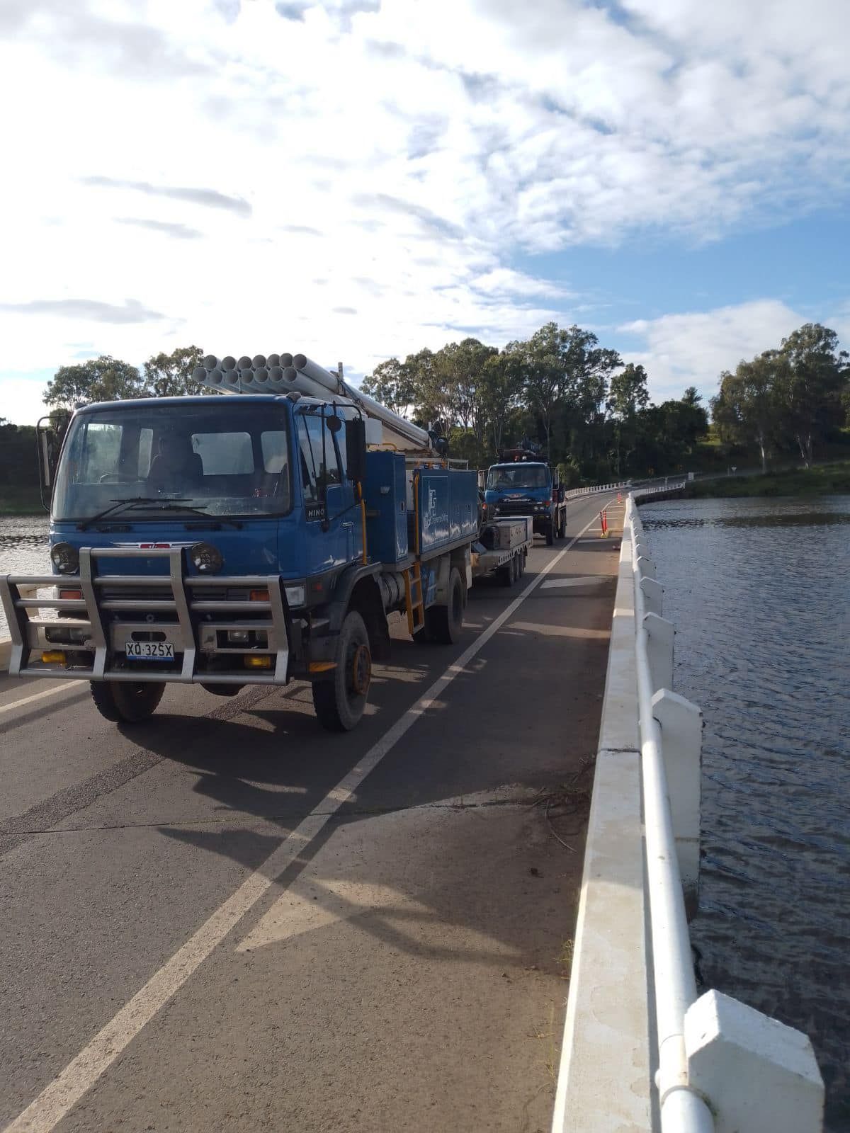 Two Trucks Are Parked on a Bridge Over a Body of Water — Cheyenne Drilling on the Sunshine Coast, QLD