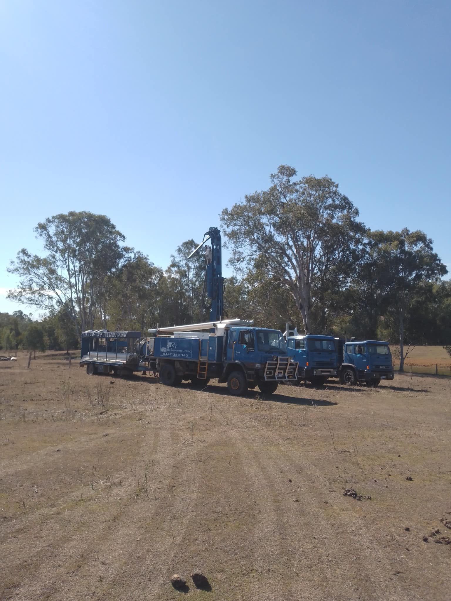 A Row of Blue Trucks Are Parked in a Dirt Field — Cheyenne Drilling on the Sunshine Coast, QLD