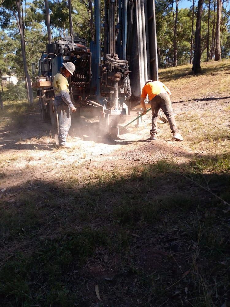 A Man in an Orange Shirt is Working on a Machine — Cheyenne Drilling on the Sunshine Coast, QLD
