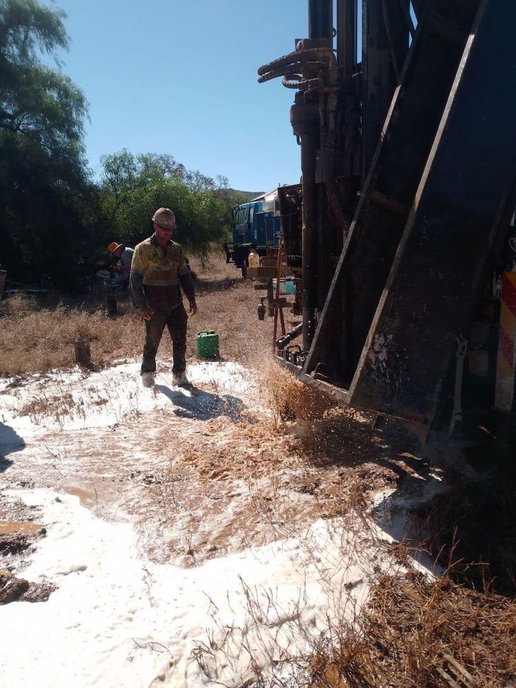 A Man is Standing in the Dirt in Front of a Machine — Cheyenne Drilling on the Sunshine Coast, QLD