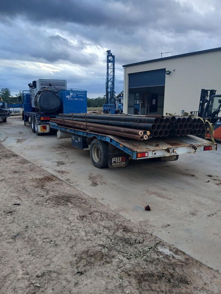 A Truck is Carrying Pipes on a Flatbed Trailer — Cheyenne Drilling on the Sunshine Coast, QLD