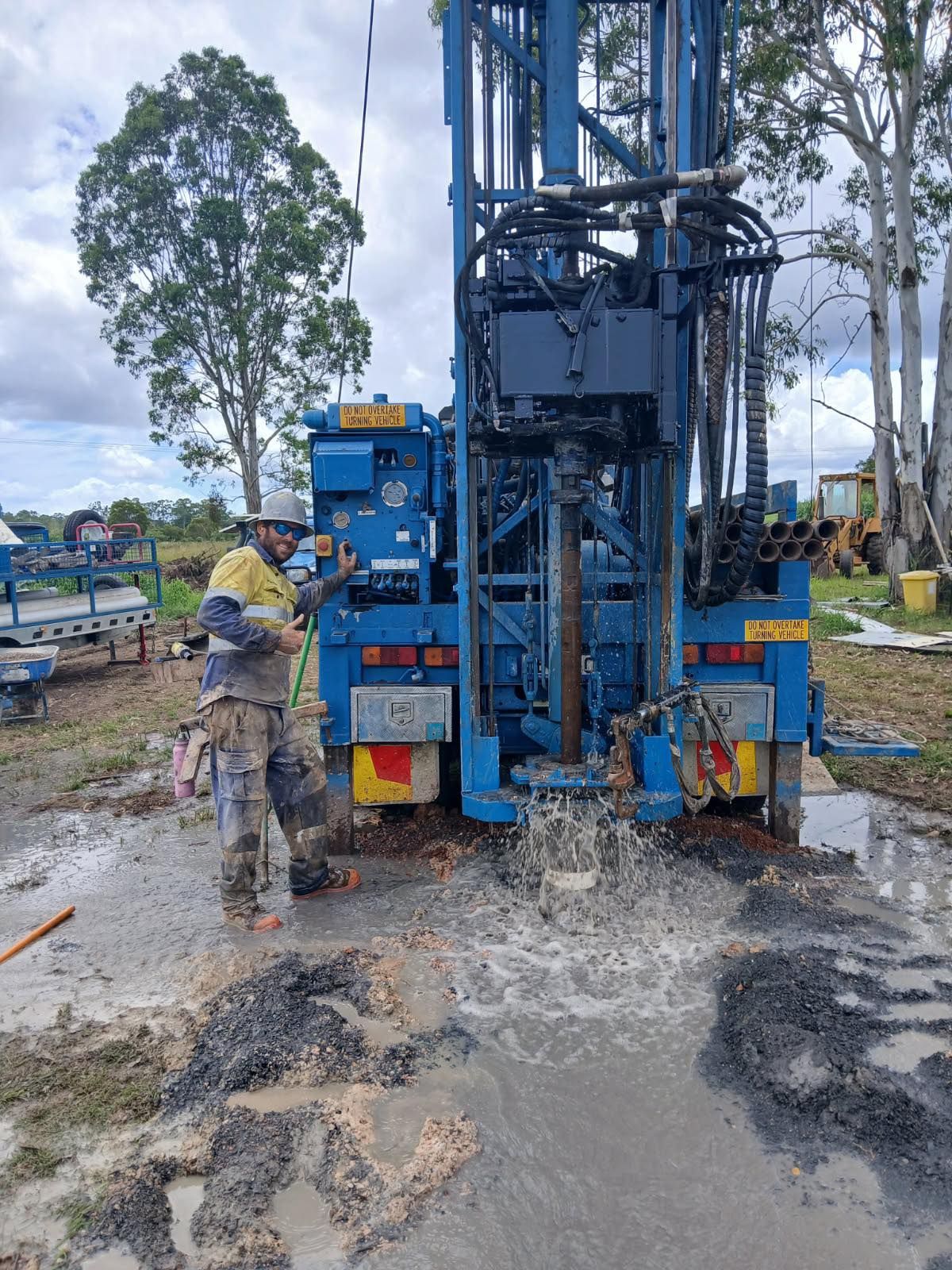 A Man and a Woman Are Standing Next to a Pole in a Dirt Field — Cheyenne Drilling on the Sunshine Coast, QLD