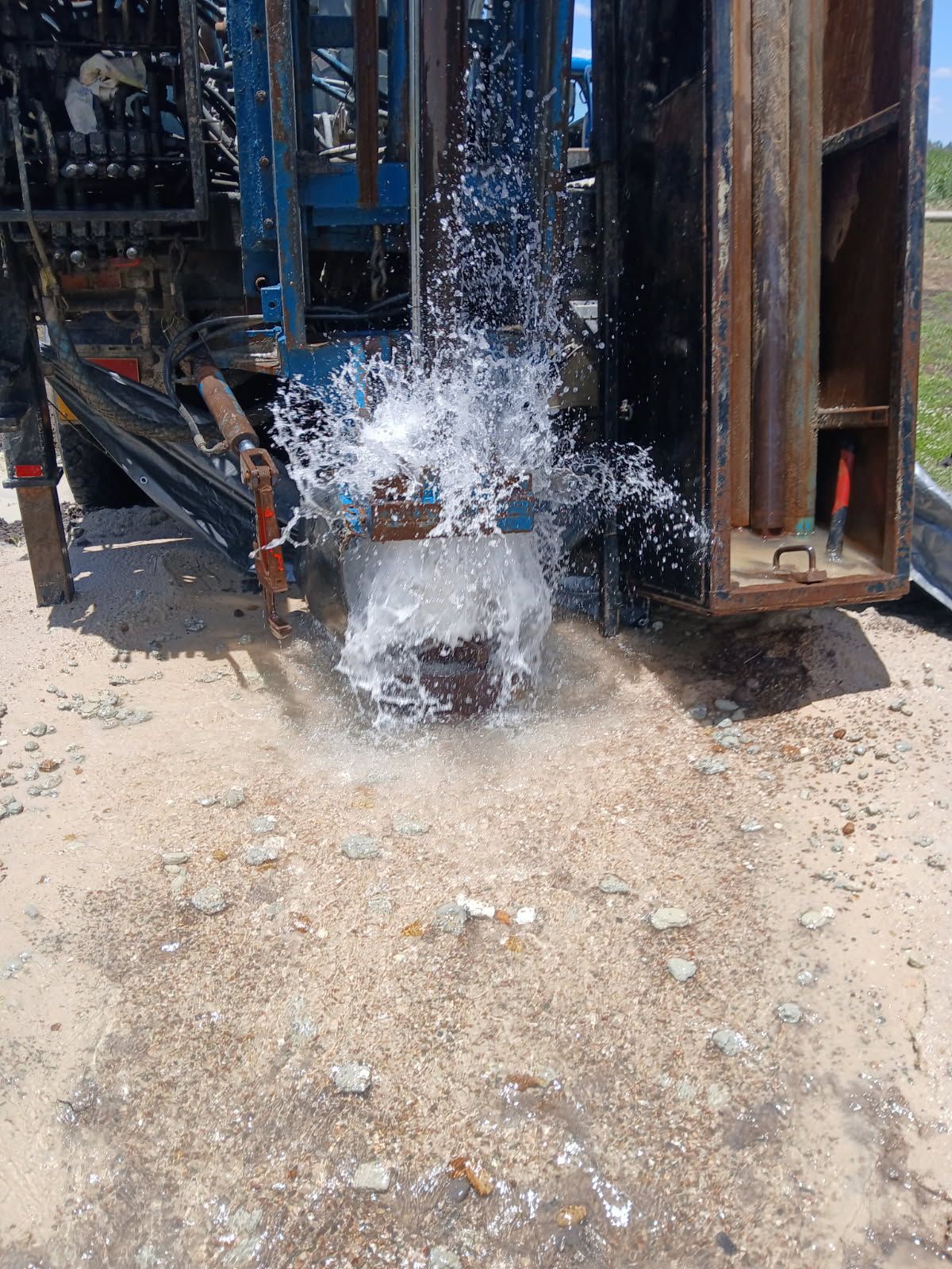 Water gushes out from a well drilling rig on a gravelly surface — Cheyenne Drilling on the Sunshine Coast, QLD