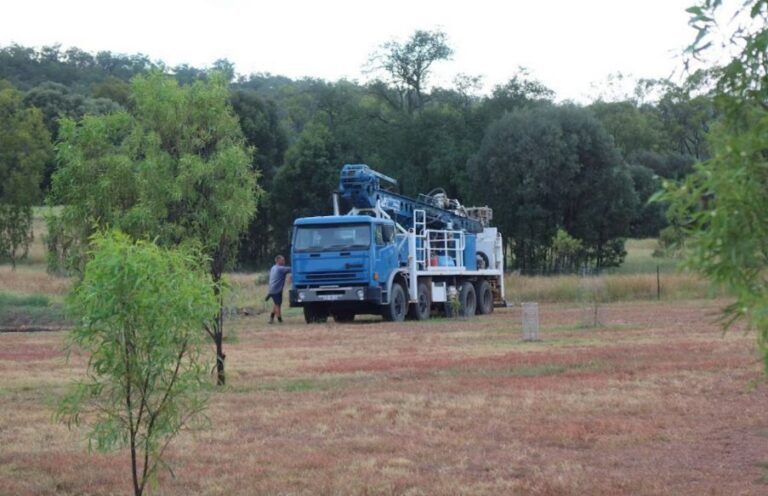 A Blue Truck is Parked in a Field With Trees in the Background — Cheyenne Drilling on the Sunshine Coast, QLD