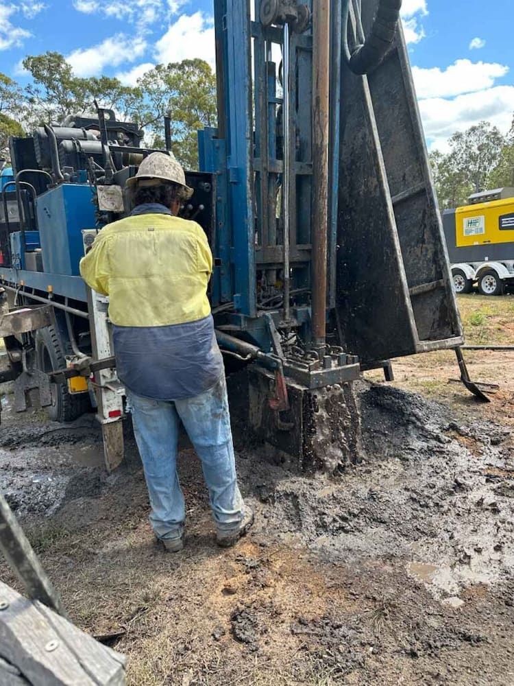 A Man is Standing in Front of a Machine in the Dirt — Cheyenne Drilling on the Sunshine Coast, QLD