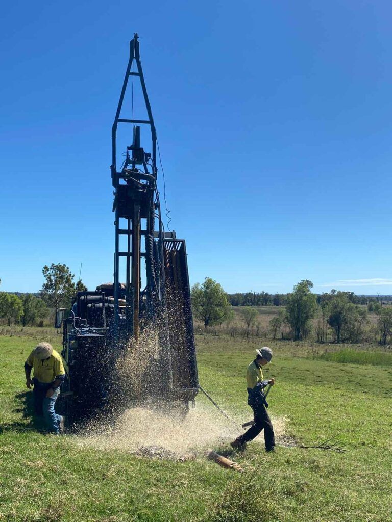 Two Men Are Working on a Drilling Rig in a Grassy Field — Cheyenne Drilling on the Sunshine Coast, QLD